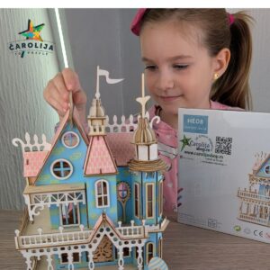 Devojčica slaže 3D drvenu slagalicu Plava Vila Fantazija uz kutiju proizvoda iz ČarolijaShop-a.