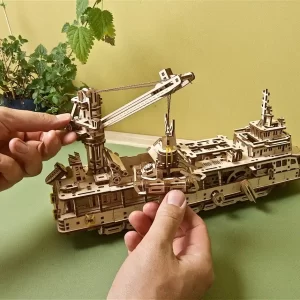 3d drvena slagalica istraživacki brod na stolu uz par ruku