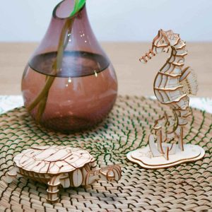 3d drvene slagalice na stolu pored vaze sa cvecem